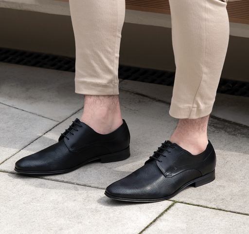 Crne muške cipele od kože u kombinaciji s bež hlačama